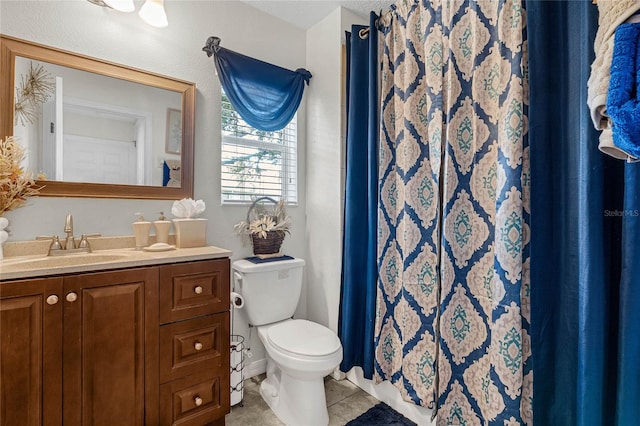 bathroom with vanity, toilet, walk in shower, and tile patterned flooring