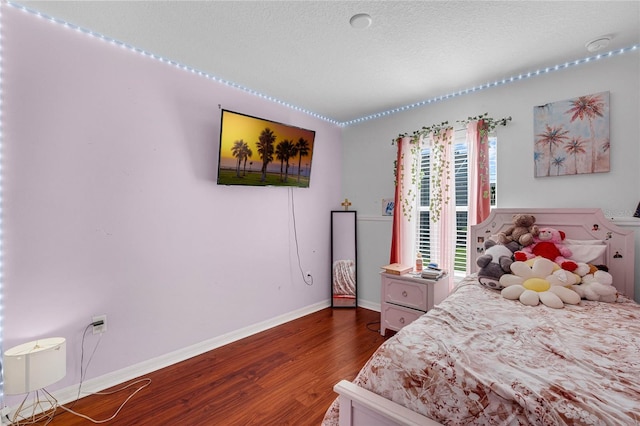 bedroom with dark wood-type flooring and a textured ceiling