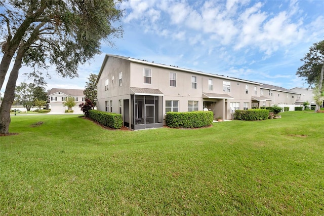 rear view of property featuring a yard and a sunroom