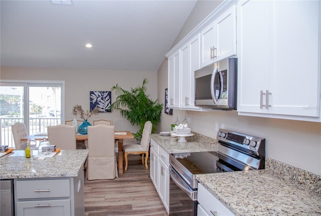 kitchen featuring appliances with stainless steel finishes, white cabinetry, and vaulted ceiling