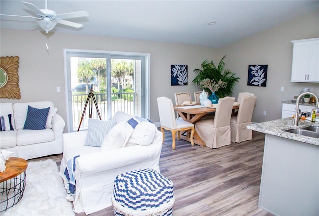 living room featuring ceiling fan, hardwood / wood-style flooring, lofted ceiling, and sink