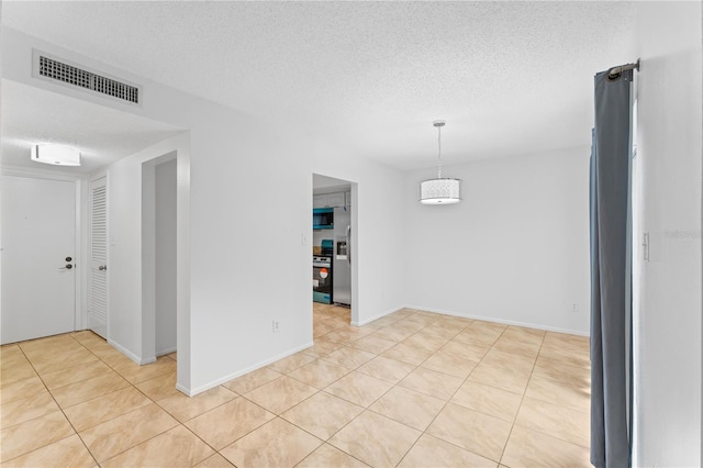 tiled empty room with a textured ceiling