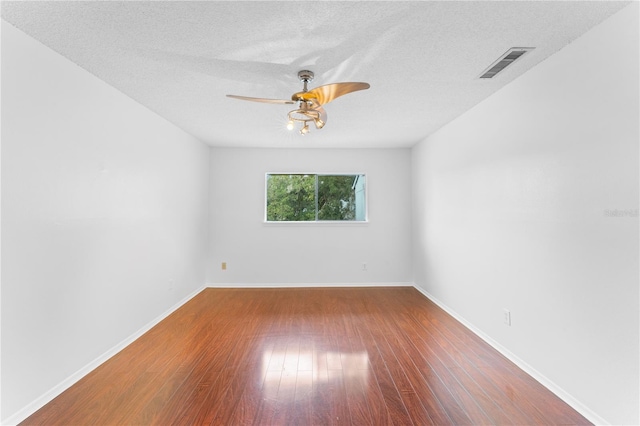 empty room with a textured ceiling, hardwood / wood-style flooring, and ceiling fan