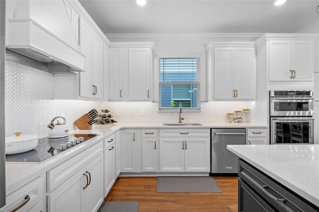 kitchen featuring hardwood / wood-style flooring, appliances with stainless steel finishes, sink, and white cabinets