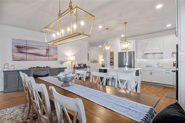 dining area featuring crown molding and light wood-type flooring