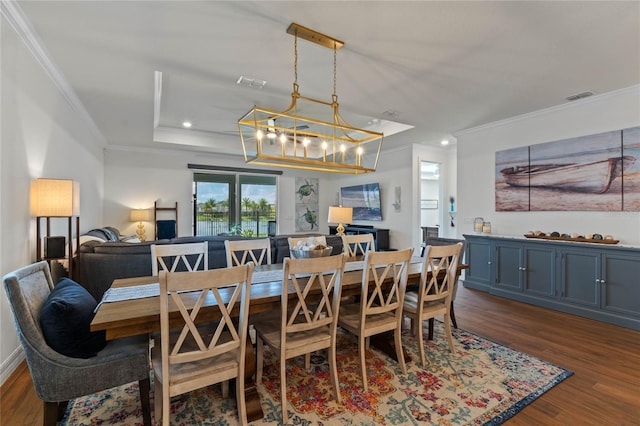 dining space with crown molding, dark hardwood / wood-style floors, and a chandelier