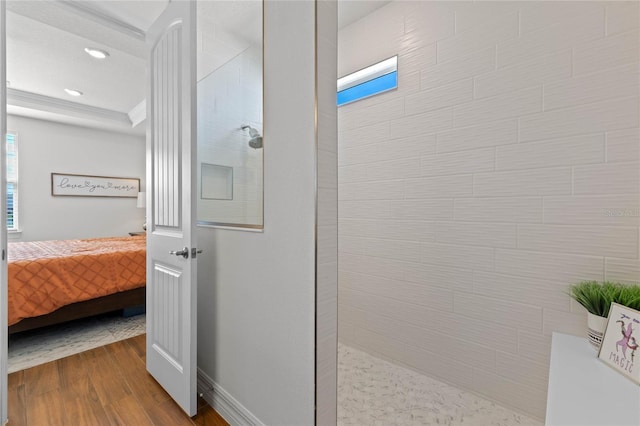 bathroom with hardwood / wood-style flooring and tiled shower