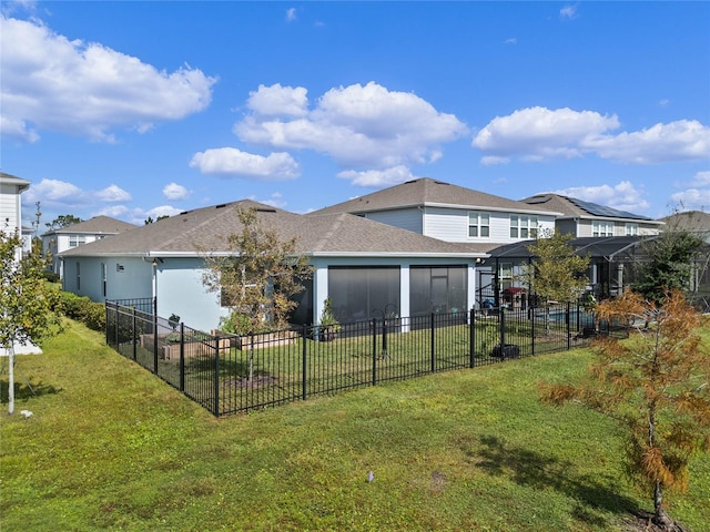 rear view of property with a yard and a sunroom