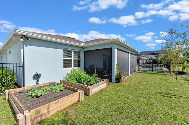 rear view of house with a yard, a sunroom, and a swimming pool