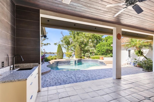 view of swimming pool featuring a patio area, ceiling fan, sink, and an in ground hot tub