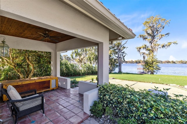 view of patio / terrace featuring ceiling fan and a water view