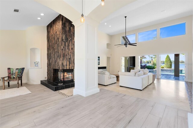 living room with ceiling fan, high vaulted ceiling, and light hardwood / wood-style floors