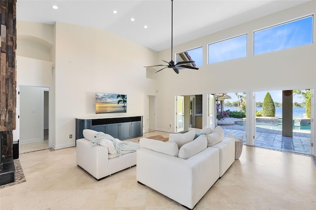 living room with a water view, high vaulted ceiling, a wealth of natural light, and ceiling fan