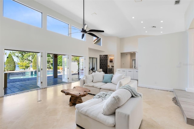 living room with ceiling fan and a high ceiling