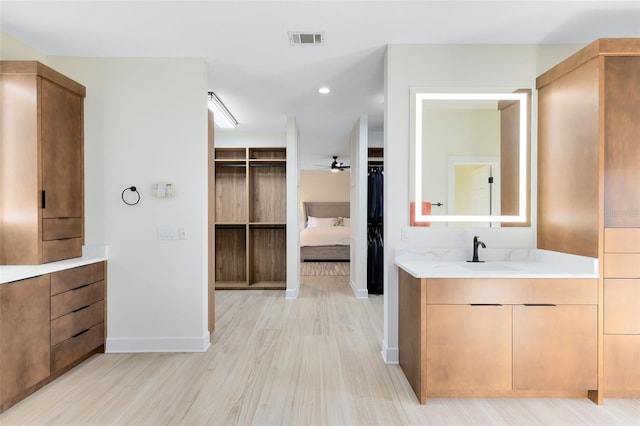 bathroom with hardwood / wood-style floors, vanity, and ceiling fan