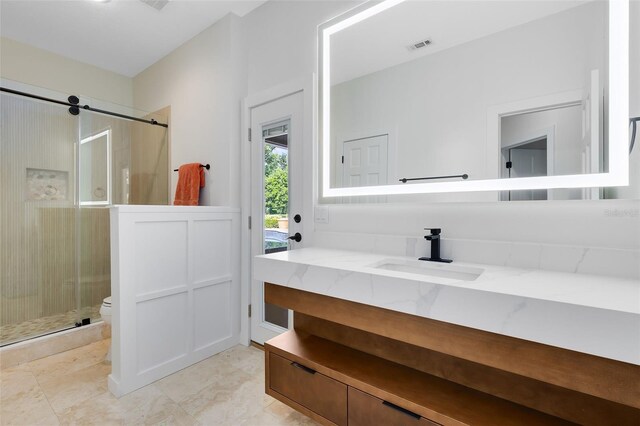 bathroom with toilet, vanity, and walk in shower