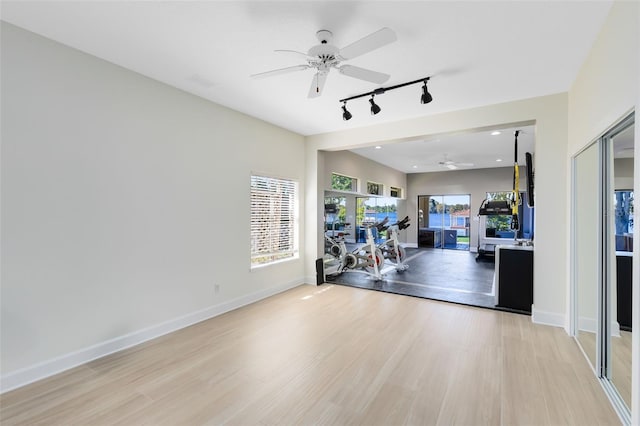 interior space featuring rail lighting, light hardwood / wood-style floors, and ceiling fan