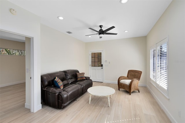 living room with light hardwood / wood-style floors and ceiling fan