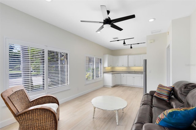 living room with ceiling fan, light hardwood / wood-style flooring, and track lighting