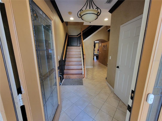 tiled foyer entrance with crown molding