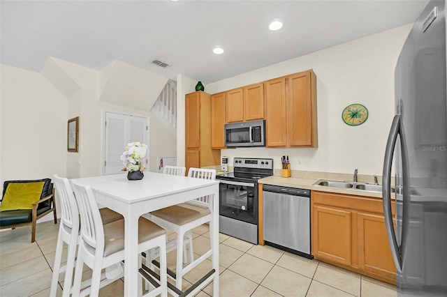 kitchen with sink, light tile patterned floors, and appliances with stainless steel finishes