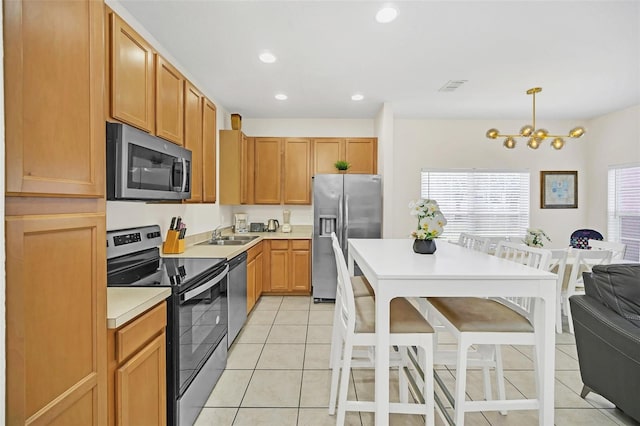 kitchen with a wealth of natural light, decorative light fixtures, light tile patterned flooring, and stainless steel appliances