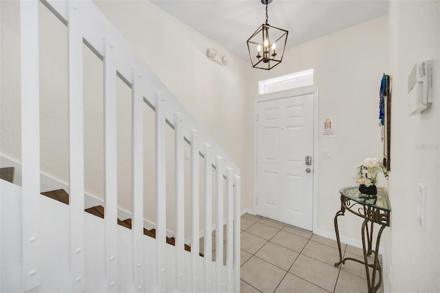 tiled foyer featuring a notable chandelier