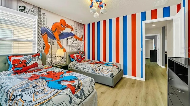 bedroom with hardwood / wood-style flooring and a notable chandelier