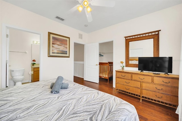 bedroom featuring ensuite bath, dark wood-type flooring, and ceiling fan