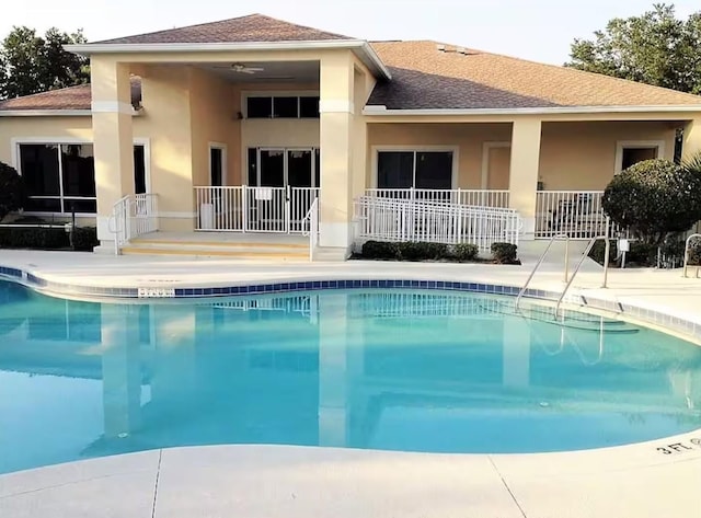 back of house with a community pool and a patio