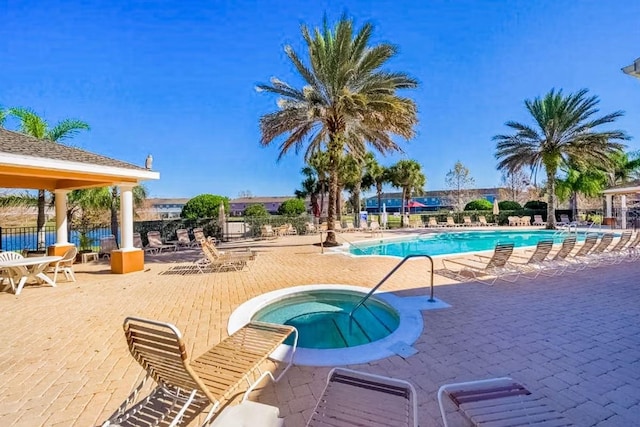 view of swimming pool with a hot tub and a patio area