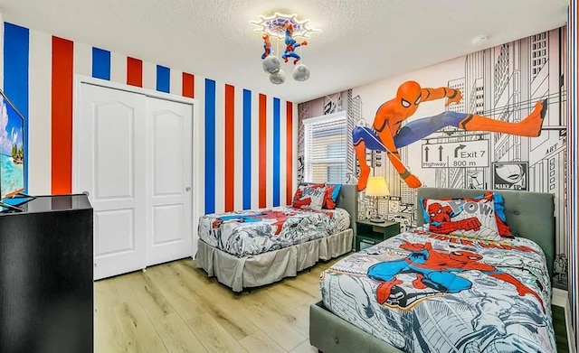 bedroom featuring a textured ceiling, hardwood / wood-style flooring, and a closet