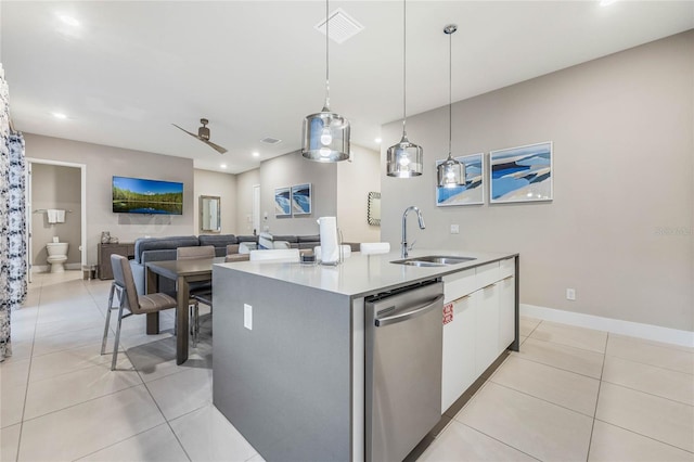 kitchen with stainless steel dishwasher, ceiling fan, sink, hanging light fixtures, and an island with sink