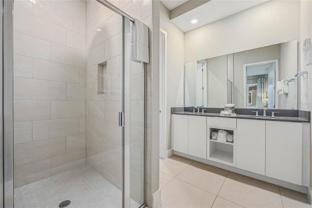 bathroom featuring tile patterned floors, a shower with door, and vanity