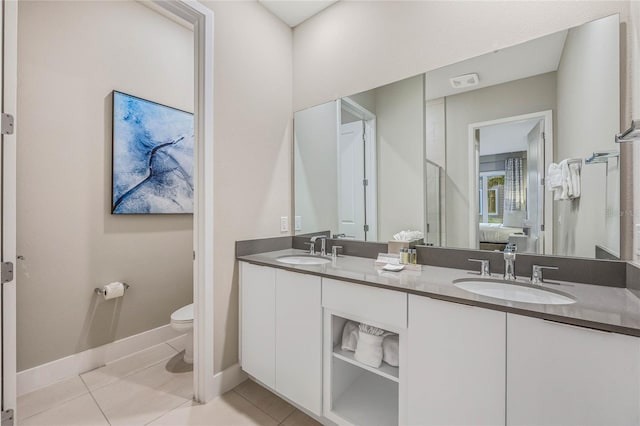 bathroom featuring tile patterned flooring, vanity, and toilet