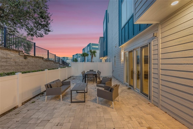 patio terrace at dusk featuring an outdoor living space