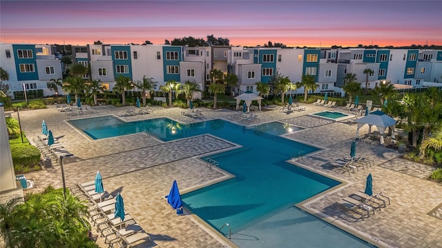 pool at dusk featuring a patio area