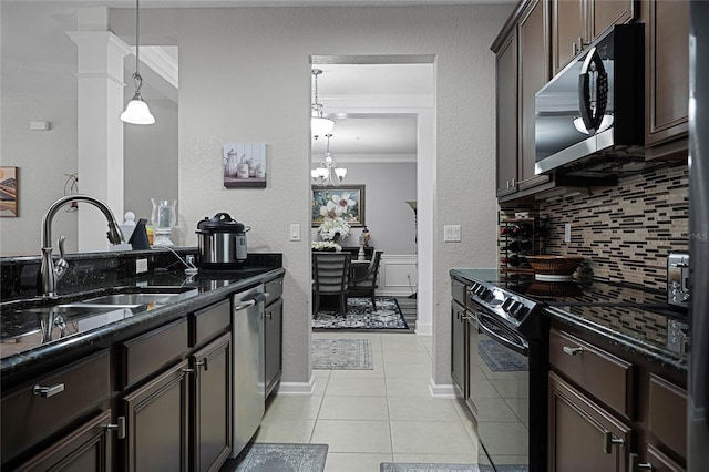 3356 Robert Trent Jones Dr Unit 101, Orlando, FL 32835 - kitchen with stainless steel appliances, a sink, ornamental molding, backsplash, and dark stone counters