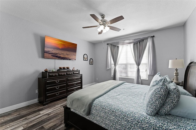 bedroom with dark hardwood / wood-style flooring, a textured ceiling, and ceiling fan