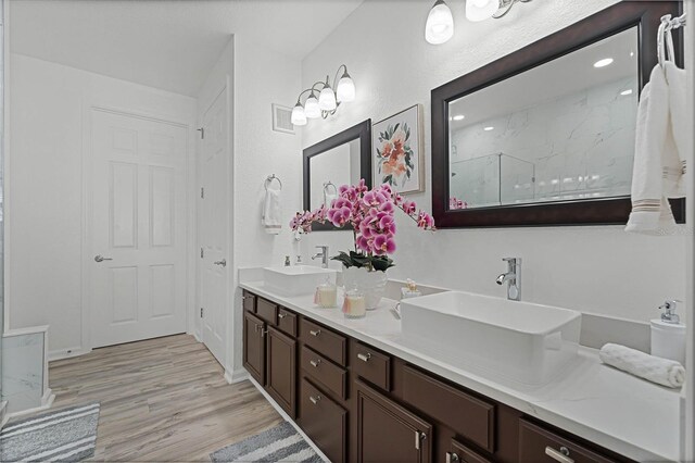 bathroom with vanity, hardwood / wood-style flooring, and a shower