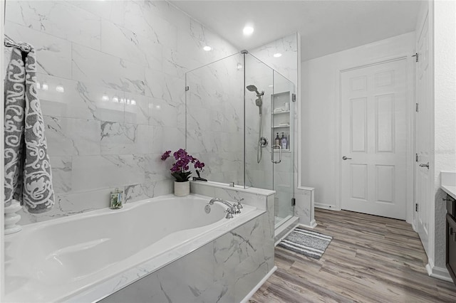 bathroom with vanity, independent shower and bath, and wood-type flooring