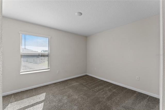 carpeted spare room featuring a textured ceiling