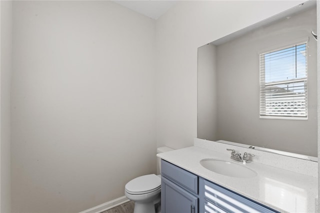 bathroom featuring toilet, vanity, and hardwood / wood-style floors