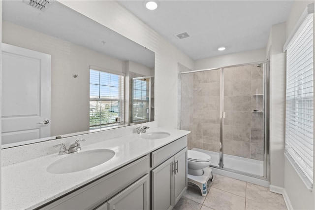 bathroom with a shower with shower door, vanity, toilet, and tile patterned flooring