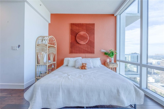 bedroom featuring dark hardwood / wood-style flooring and a wall of windows