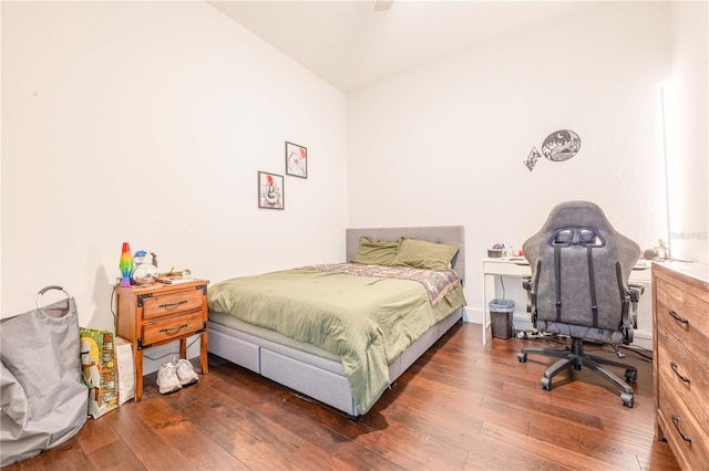 bedroom featuring ceiling fan, dark wood-type flooring, and lofted ceiling