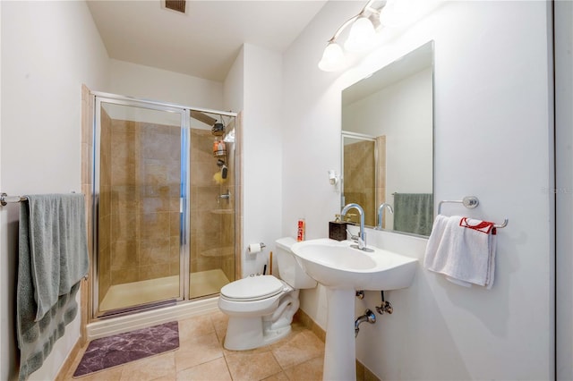 bathroom with tile patterned floors, sink, walk in shower, and toilet