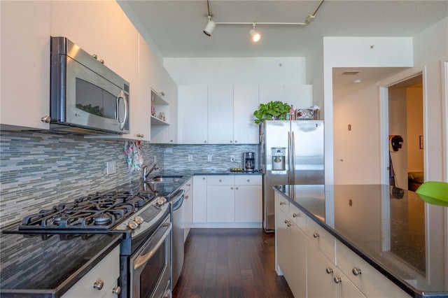 kitchen with sink, dark wood-type flooring, decorative backsplash, white cabinets, and appliances with stainless steel finishes