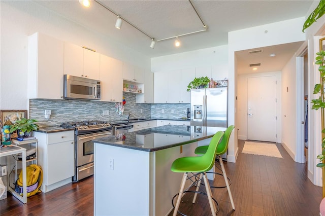 kitchen with white cabinets, stainless steel appliances, and dark wood-type flooring