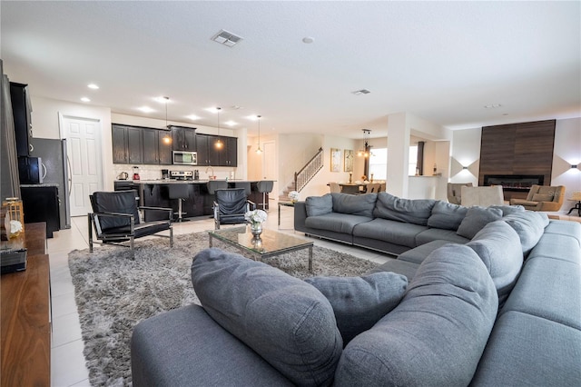 living room with light tile patterned floors, a large fireplace, and sink